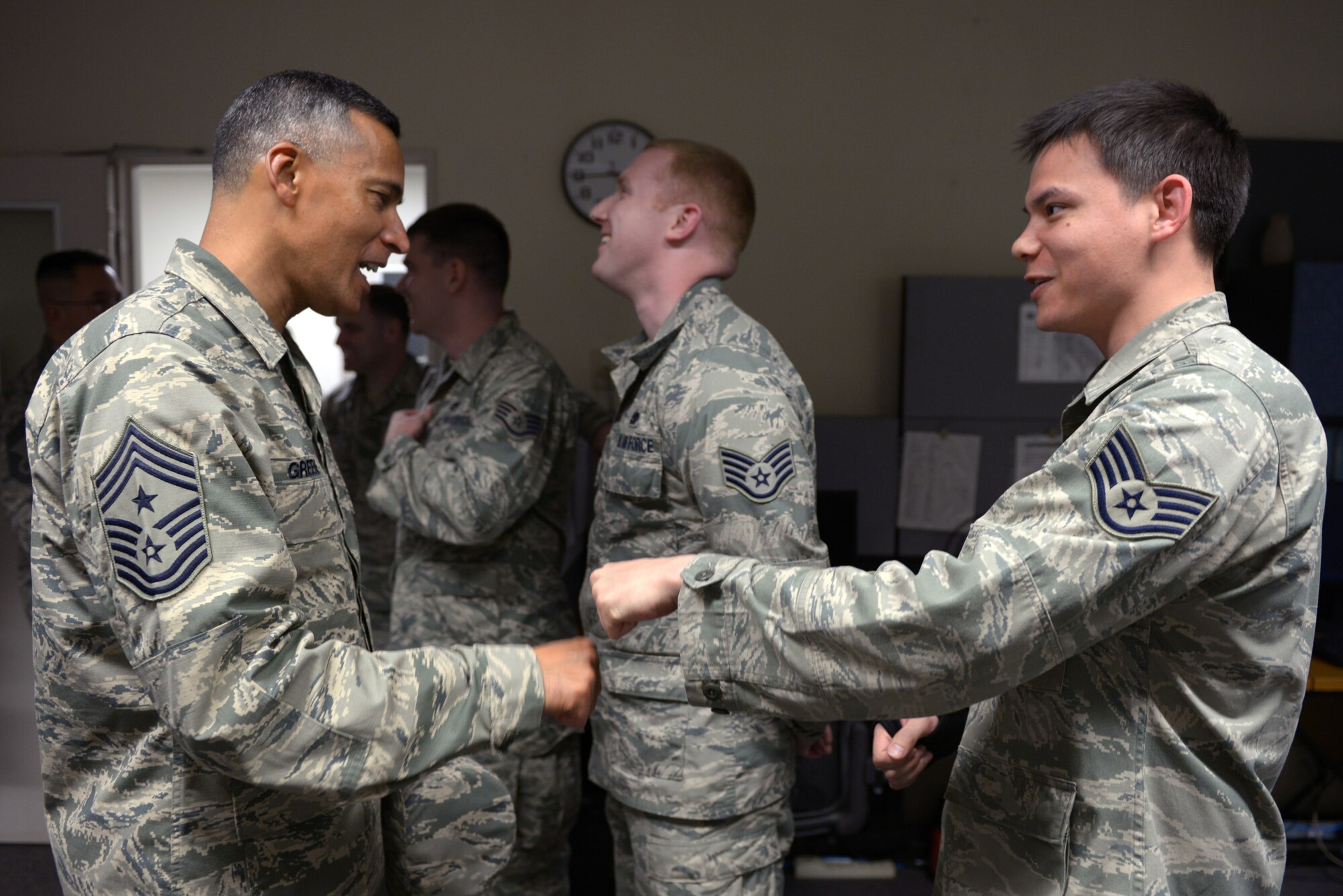 Chief Master Sgt. Terrence Greene, United States Forces, Japan and 5th Air Force command chief, fist bumps Staff Sgt. Eric Bable, 730th Air Mobility Squadron crew chief, during his immersion tour at Yokota Air Base, Japan, April 6, 2016. Greene spent two days touring Yokota meeting Airmen with the 374th Airlift Wing, the installation host unit, and other partner units. (U.S. Air Force photo by Staff Sgt. Cody H. Ramirez/Released)