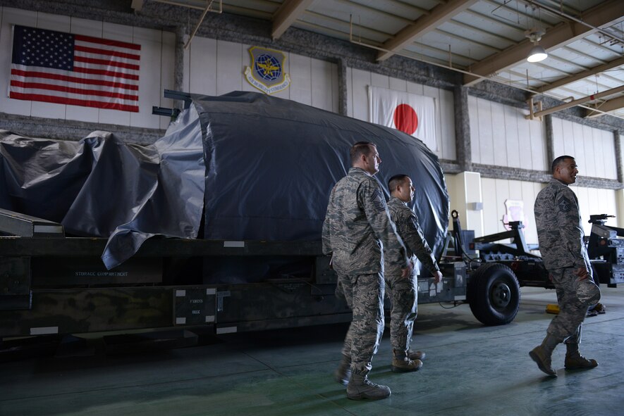 Chief Master Sgt. Terrence Greene (right), United States Forces, Japan and 5th Air Force command chief, tours a maintenance facility with the 730th Air Mobility Squadron during his immersion tour at Yokota Air Base, Japan, April 6, 2016. Greene spent two days touring Yokota meeting Airmen with the 374th Airlift Wing, the installation host unit, and other partner units. (U.S. Air Force photo by Staff Sgt. Cody H. Ramirez/Released)