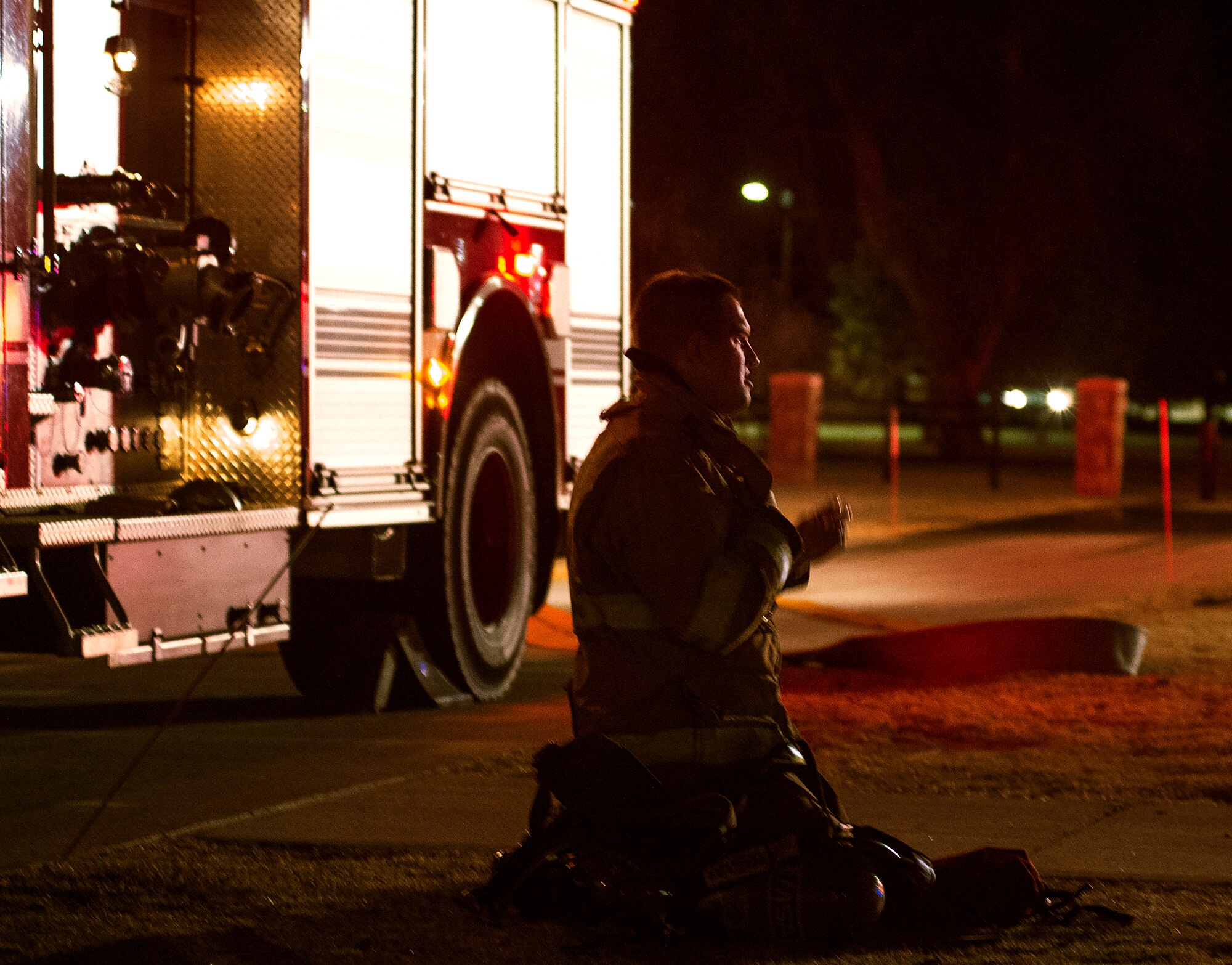 A firefighter with the F.E. Warren Air Force Base, Wyo., Fire Department takes his air tank and mask off the evening of March 9, 2016, outside of the 90th Missile Wing headquarters building. The fire department responded to a fire alarm after the custodian smelled smoke in the building. (U.S. Air Force photo by R.J. Oriez)