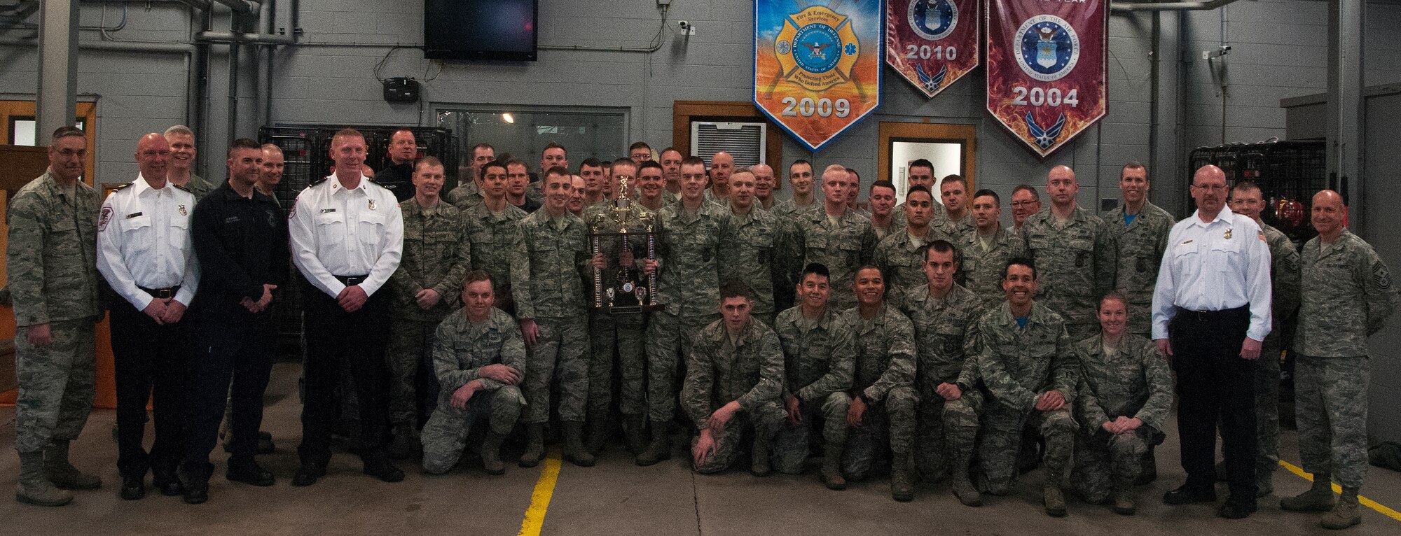 Col. Stephen Kravitsky, 90th Missile Wing commander, and Chief Master Sgt. Samuel Couch, 90th MW command chief, pose with the 90th Civil Engineer Squadron fire department March 29, 2016 inside the F.E. Warren Air Force Base, Wyo., fire station. Kravitsky formally presented the department with the Air Force Chief Master Sgt. Ralph E. Sanborn Fire Department of the Year award for the best small base in the Air Force. (U.S. Air Force photo by Senior Airman Brandon Valle)