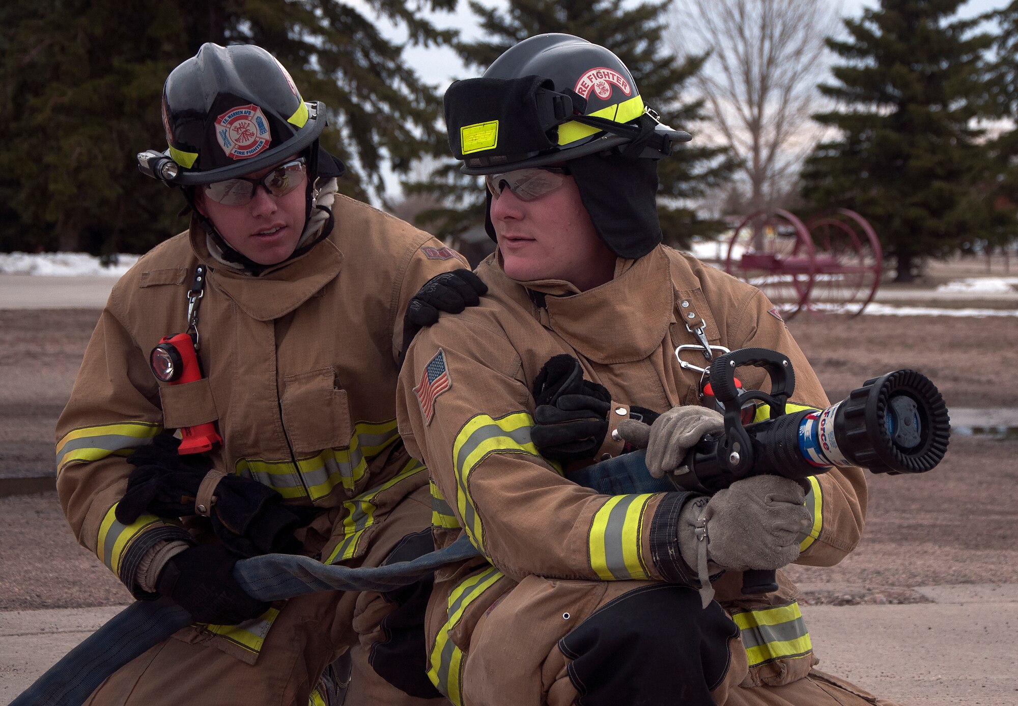 Airmen 1st Class Augustus Whitt and Tom Were, 90th Civil Engineer Squadron firefighters, test a fire hose March 29, 2016, in front of the fire station of F.E. Warren Air Force Base, Wyo. The department recently received the Air Force Chief Master Sgt. Ralph E. Sanborn Fire Department of the Year award for the best small base in the Air Force. (U.S. Air Force photo by Senior Airman Brandon Valle)