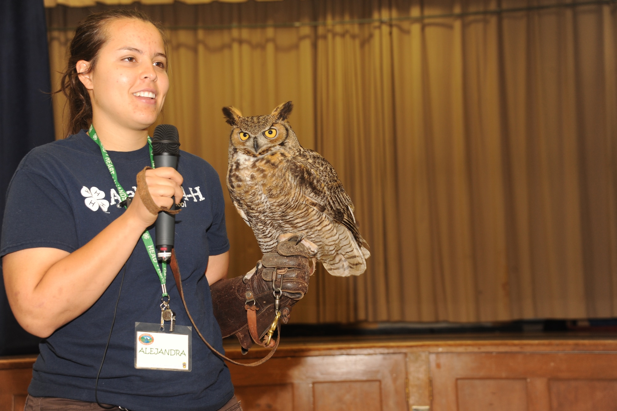 Alejandra Palacio, Alabama 4-H Science School environmental educational instructor, displays a Great Horned Owl to Maxwell Elementary and Middle School students during the Birds of Prey demonstration April 8, 2016, at Maxwell Air Force Base, Alabama. The Birds of Prey program strives to educate youth on the importance of protecting the environment and the animals within it. (U.S. Air Force photos by Airman 1st Class Alexa Culbert)