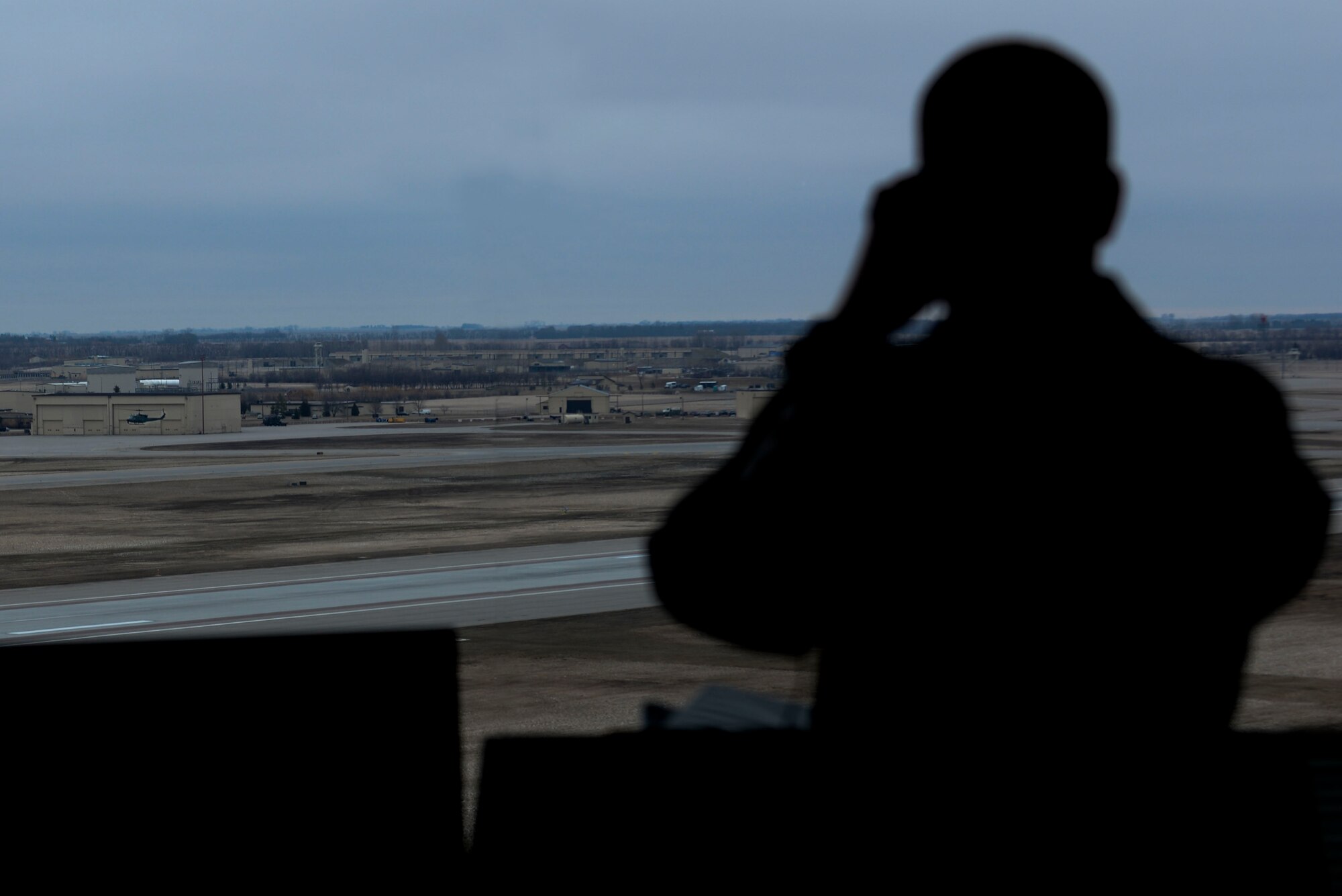 A 5th Operations Support Squadron Airman from the Air Traffic Control tower at Minot Air Force Base, N.D., watches a helicopter land April 6, 2016. The primary responsibility of controllers is to support the nuclear mission through separation of aircraft and provide expeditious service to Team Minot. (U.S. Air Force photo/Airman 1st Class Jessica Weissman)