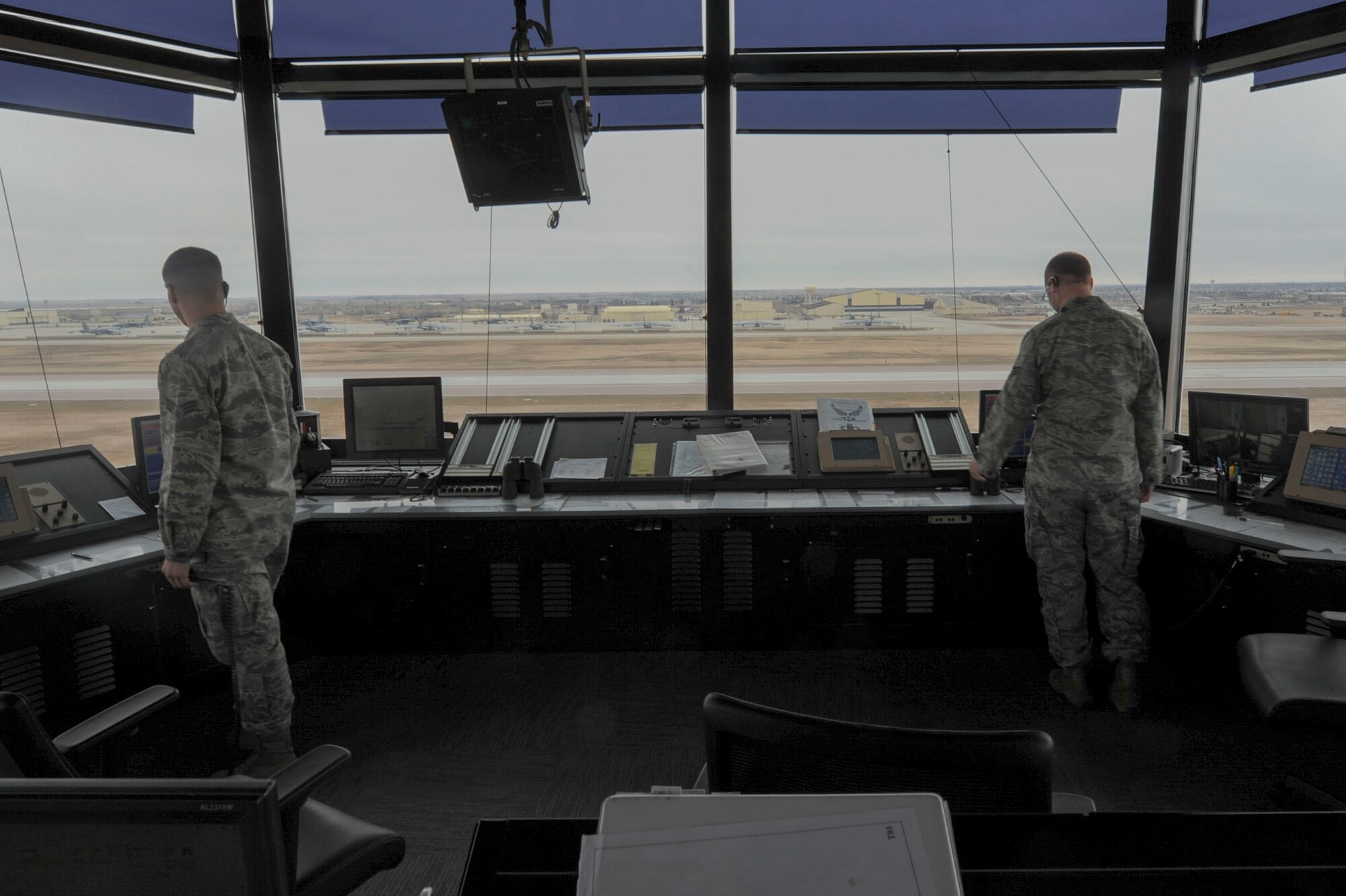 5th Operations Support Squadron Airmen from the Air Traffic Control tower at Minot Air Force Base, N.D., monitor the flight line April 6, 2016. The primary responsibility of controllers is to support the nuclear mission through separation of aircraft and provide expeditious service to Team Minot. (U.S. Air Force photo/Airman 1st Class Jessica Weissman)