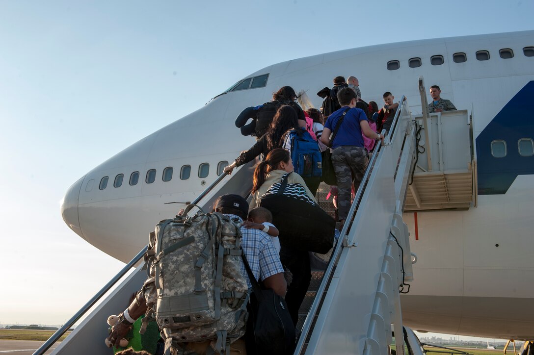 Families of U.S. Airmen and families of Department of Defense civilians ascend a flight of stairs to board an Atlas Air 747 airliner April 1, 2016 at Incirlik Air Base, Turkey. Department of Defense dependents and civilians were ordered to depart Incirlik AB March 29, 2016. (U.S. Air Force photo by Staff Sgt. Jack Sanders/Released)