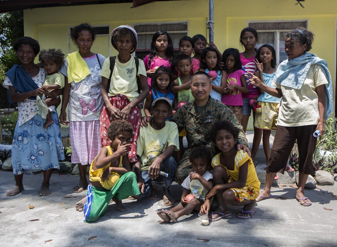 U.S. sailor Hospital Corpsman 1st Class Jose G. Esguerra poses for a photo with Philippine families from Maruglo Elementary School, at Crow Valley, Philippines, April 7, 2016. Esguerra is a dental technician with 3rd Dental Battalion, 11th Dental Regiment, currently attached to 3rd Medical Battalion, 3rd Marine Division, III Marine Expeditionary Force. Esguerra has been in the Navy for 17 years and for the first time, returned home to give back to his country. (U.S. Photo by Lance Cpl. Jessica N. Etheridge/Released)