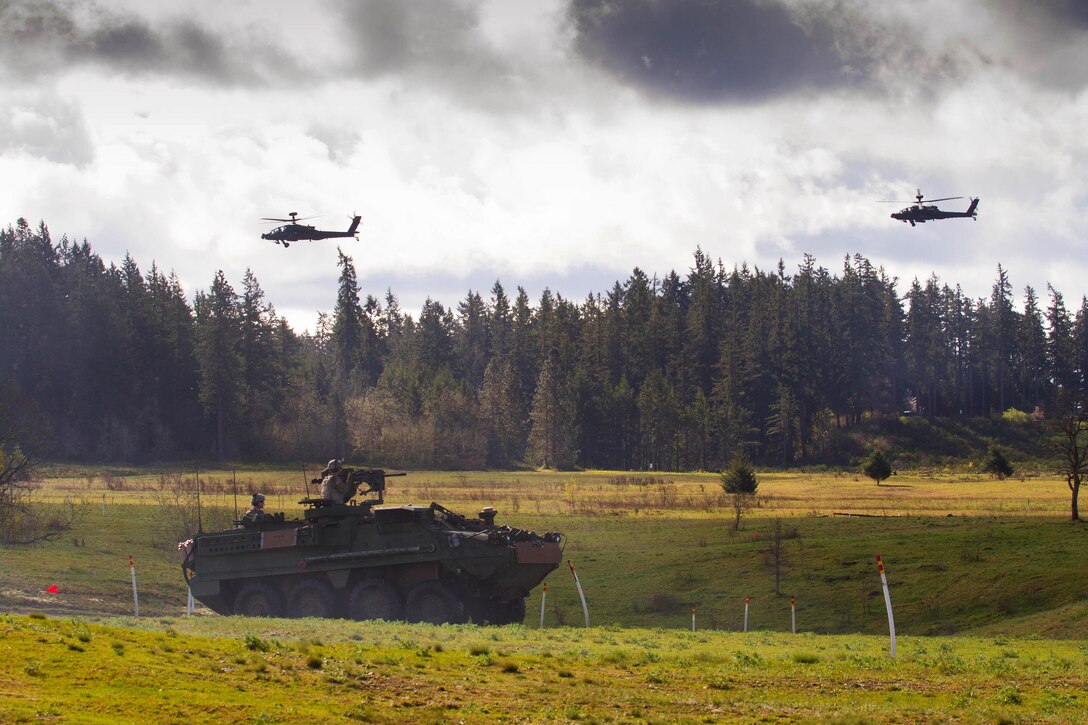 Two AH-64E Apache helicopters provide aerial security for soldiers in a Stryker armored combat vehicle during a combined arms live-fire exercise at Joint Base Lewis-McChord, Wash., April 4, 2016. The soldiers are assigned to the 2nd Infantry Division’s 2nd Stryker Brigade Combat Team and the Apache crews are assigned to the 7th Infantry Division’s 16th Combat Aviation Brigade. Army photo by Capt. Brian H. Harris