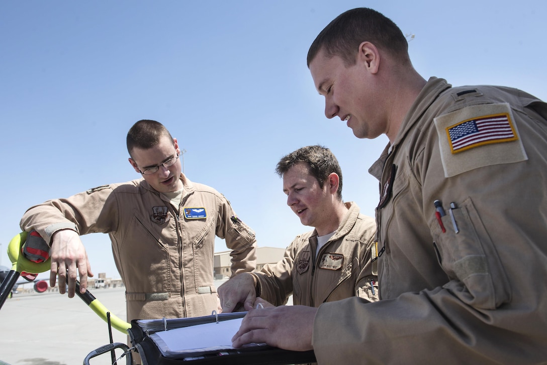 Air Force airmen review preflight checklist procedures before departing from Al Udeid Air Base, Qatar, April 5, 2016, in support of Operation Inherent Resolve. The airmen are assigned to the 340th Expeditionary Air Refueling Squadron. Air Force photo by Staff Sgt. Corey Hook