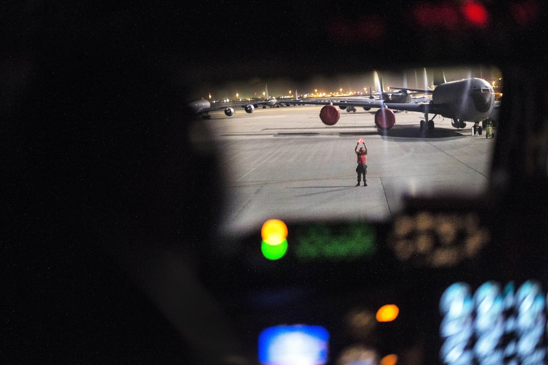 An Air Force crew chief marshals a KC-135 Stratotanker at Al Udeid Air Base, Qatar, April 5, 2016, after a refueling mission in support of Operation Inherent Resolve. Air Force photo by Staff Sgt. Corey Hook