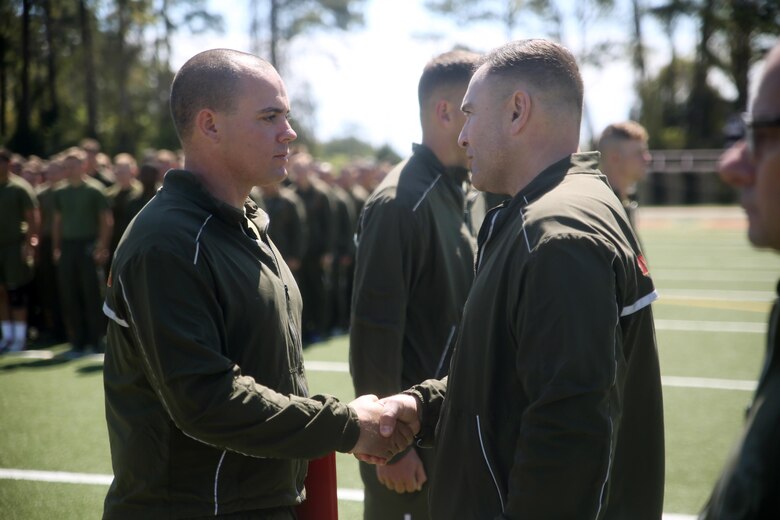 Sgt. Benjamin D. Patrick (left)shakes hands with Lt. Col. Anthony J. Bango, battalion commander, both with 2nd Light Armored Reconnaissance Battalion, during an award presentation at Camp Lejeune, N.C., April 8, 2016. Patrick won the competition and was awarded the Navy and Marine Corps Achievement Medal, a four-day weekend, and the title “2nd LAR’s Best Scout.” (U.S. Marine Corps photo by Cpl. Joey Mendez)