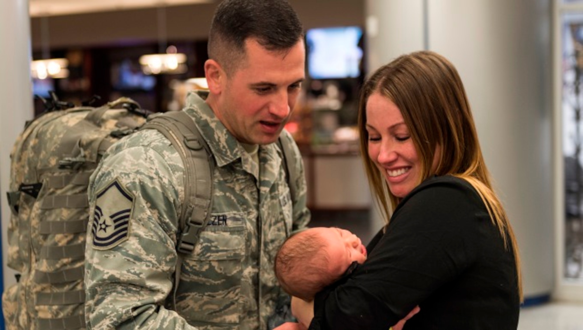 Master Sgt. Joseph Molzen, an Airman assigned to the 107th Security Forces Squadron, Niagara Falls Air Reserve Station, N.Y. gets to see his newborn daughter for the first time. Molzen was one of more than 30 Airmen from the 107th SFS to return from a six-month deployment to Southwest Asia, Feb. 4-5, 2016. (U.S. Air National Guard photo by Staff Sgt. Ryan Campbell/Released)