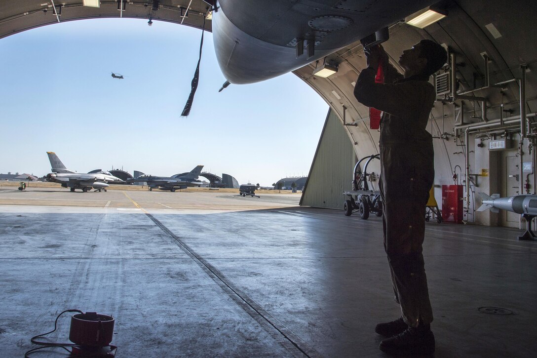 Air Force Senior Airman Kyle Lacy places probe covers on an F-16 Fighting Falcon aircraft during a surge exercise at Misawa Air Base, Japan, April 5, 2016. Lacy is a crew chief assigned to the 35th Maintenance Squadron. Air Force photo by Airman 1st Class Jordyn Fetter