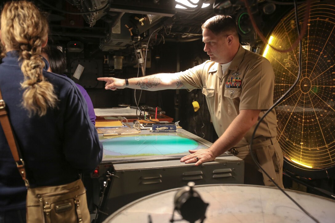 Chief Petty Officer Jeremy Moore explains to visitors the various features of the Control Information Center on the USS North Carolina (BB-52) Battleship Memorial in Wilmington, N.C., April 9, 2016. Marines and sailors from 2nd Tank Battalion and other 2nd Marine Division units volunteered to work with museum staff and members of Living History to give real-life experiences to guests partaking in the USS North Carolina’s (BB-52) 75th anniversary celebration of its commissioning. (U.S. Marine Corps photo by LCpl. Miranda Faughn/Released)