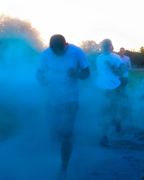 Participants of the Helping Agency 5K have blue chalk thrown at them on Barksdale Air Force Base, La., April 8, 2016. Blue, white, red, teal and orange were the five representational colors of helping agencies taking part in the 5k event. (U.S. Air Force photo/Senior Airman Jannelle Dickey)