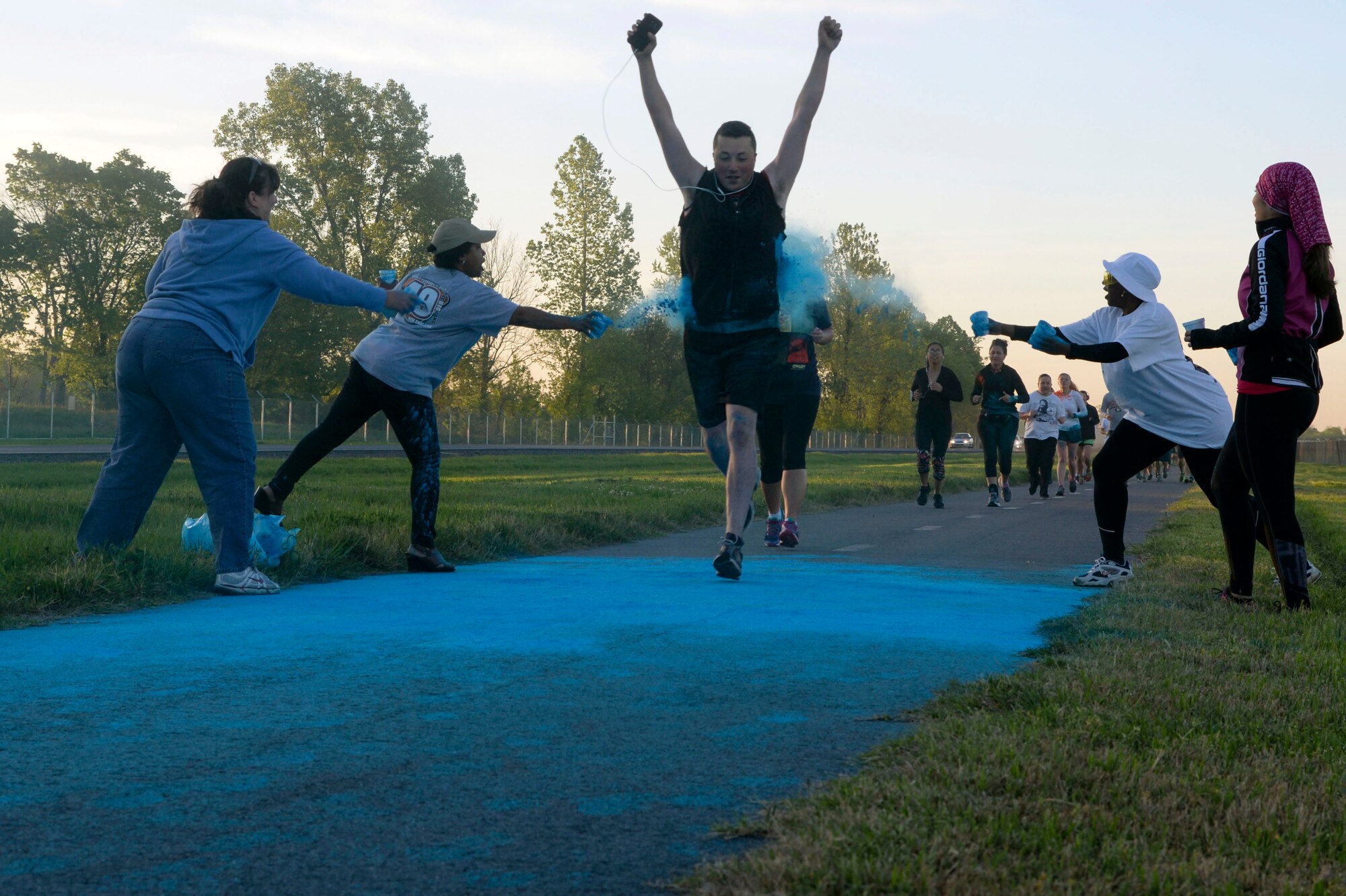 Participants of the Helping Agency 5K have blue chalk thrown at them on Barksdale Air Force Base, La. April 8, 2016. The blue chalk represented the Airmen Family Readiness Center and family advocacy programs. (U.S. Air Force photo/Senior Airman Jannelle Dickey)