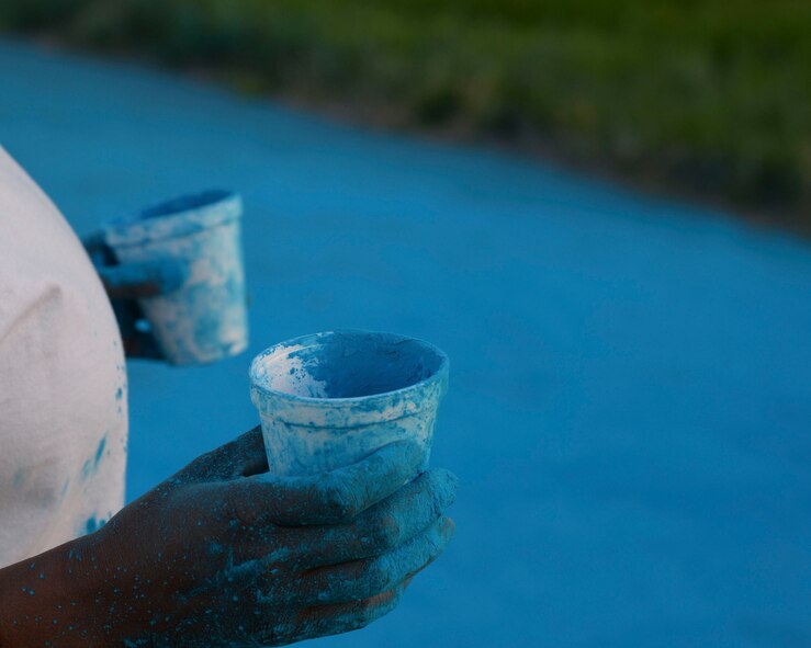 A member of 2nd Force Support Squadron waits to throw chalk at runners during the Helping Agency 5K on Barksdale Air Force Base, La., April 8, 2016. Airmen from base helping agencies were spread across the route and threw colored chalk on the runners. (U.S. Air Force photo/Senior Airman Jannelle Dickey)
