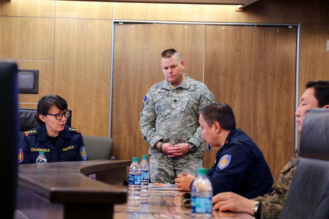 Alaska State Defense Force Lt. Col. John James, center, director of operations, answers questions from Mongolian Col. Ariunaa Chadraabal, left, and Mongolian Col. Ariunbuyan Gombojav, right, members of the Mongolian National Emergency Management Agency, during a visit to the Alaska National Guard Armory at Joint Base Elmendorf-Richardson, April 1, 2016. Members of the Mongolian Ministry of Defense and Mongolian NEMA observed the Department of Military and Veterans Affairs participation in Alaska Shield 2016. Alaska Army National Guard photo by Staff Sgt. Balinda O’Neal Dresel