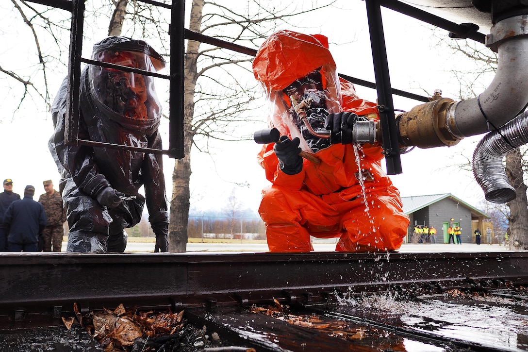 Army Sgt. Joseph St. Germain, left, and Army Staff Sgt. Andrew Markham close a valve on an Alaska railroad water tender, or tanker, during exercise Alaska Shield 2016 in Palmer, Alaska, April 2, 2016. Germain and Markham are assigned to the Alaska National Guard’s 103rd Civil Support Team. The tender served as the source of a simulated sulfuric acid leak. Alaska Army National Guard photo by Sgt. David Bedard