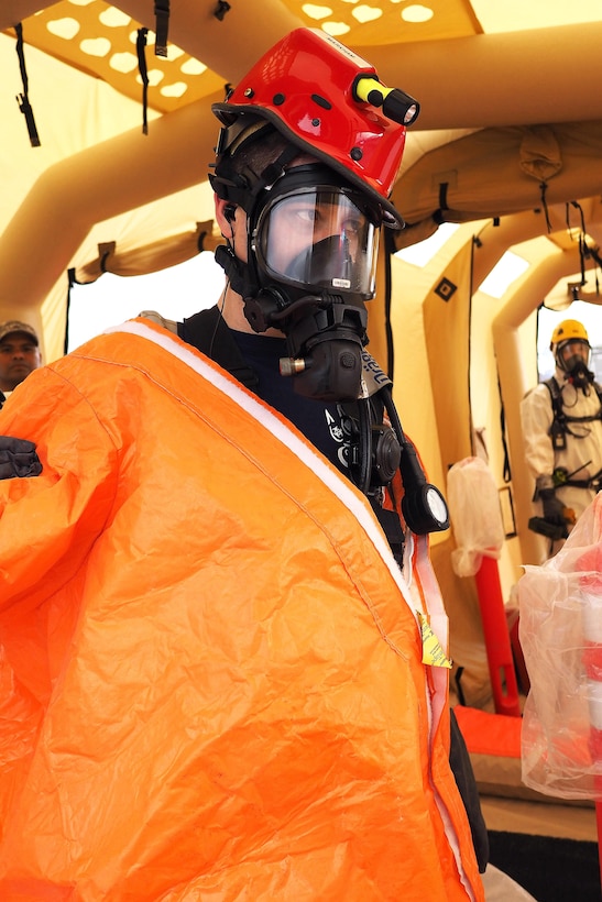 Army Staff Sgt. Andrew Markham takes off his protective suit during simulated decontamination after a simulated sulfuric acid leak at the Alaska State Fairgrounds during exercise Alaska Shield 2016, Palmer, Alaska, April 2, 2016. Markham is assigned the Alaska National Guard’s 103rd Civil Support Team. Alaska Army National Guard photo by Sgt. David Bedard
