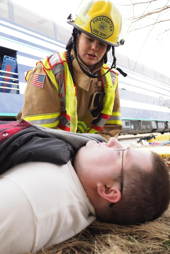 Firefighter Amy Bohmbach assesses a simulated casualty at the Alaska State Fairgrounds during exercise Alaska Shield 2016, Palmer, Alaska, April 2, 2016. Alaska State Defense Force Staff Sgt. Steven Flippen role plays as the casualty. Alaska Army National Guard photo by Sgt. David Bedard