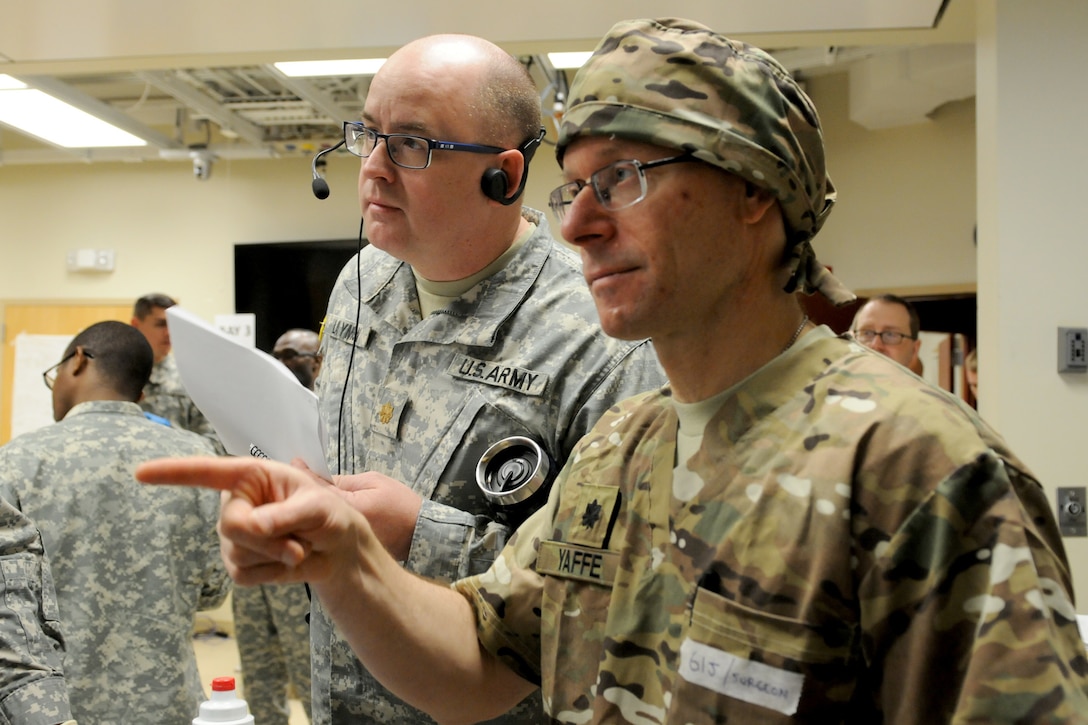 U.S. Army Reserve Maj. John Laymon (left) observes as Lt. Col. Michael Yaffe (right), a trauma surgeon with the 399th Combat Support Hospital, 804th Medical Brigade, 3d Medical Command (Deployment Support), gives direction and receives feedback from his team April 2, 2016 during an exercise at the Mayo Clinic Multidisciplinary Simulation Center in Rochester, Minnesota. Laymon, a nurse practitioner with the 4224th U.S. Army Hospital, Central Medical Area Readiness Support Group, Army Reserve Medical Command, Des Moines, Indiana, served as an observer-controller/trainer during the exercise, which focused on helping the unit implement the Team Strategies and Tools to Enhance Performance and Patient Safety, or TeamSTEPPS, framework.