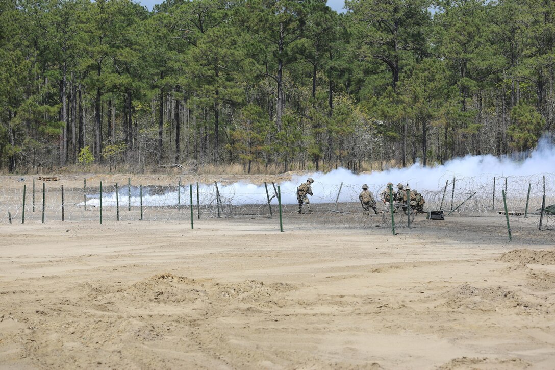Marines with 2nd Combat Engineer Battalion, 2nd Marine Division prepare another series of explosives to clear concertina wire and various defensive obstacles for the remainder of their forces to pass through during their annual Marine Corps Combat Readiness Evaluation on Camp Lejeune, N.C., April 4-8, 2016.The Marines operated in two groups, each group preparing to engage two different sides of the defensive obstacles.(U.S. Marine Corps photo by Cpl. Shannon Kroening/ Released)