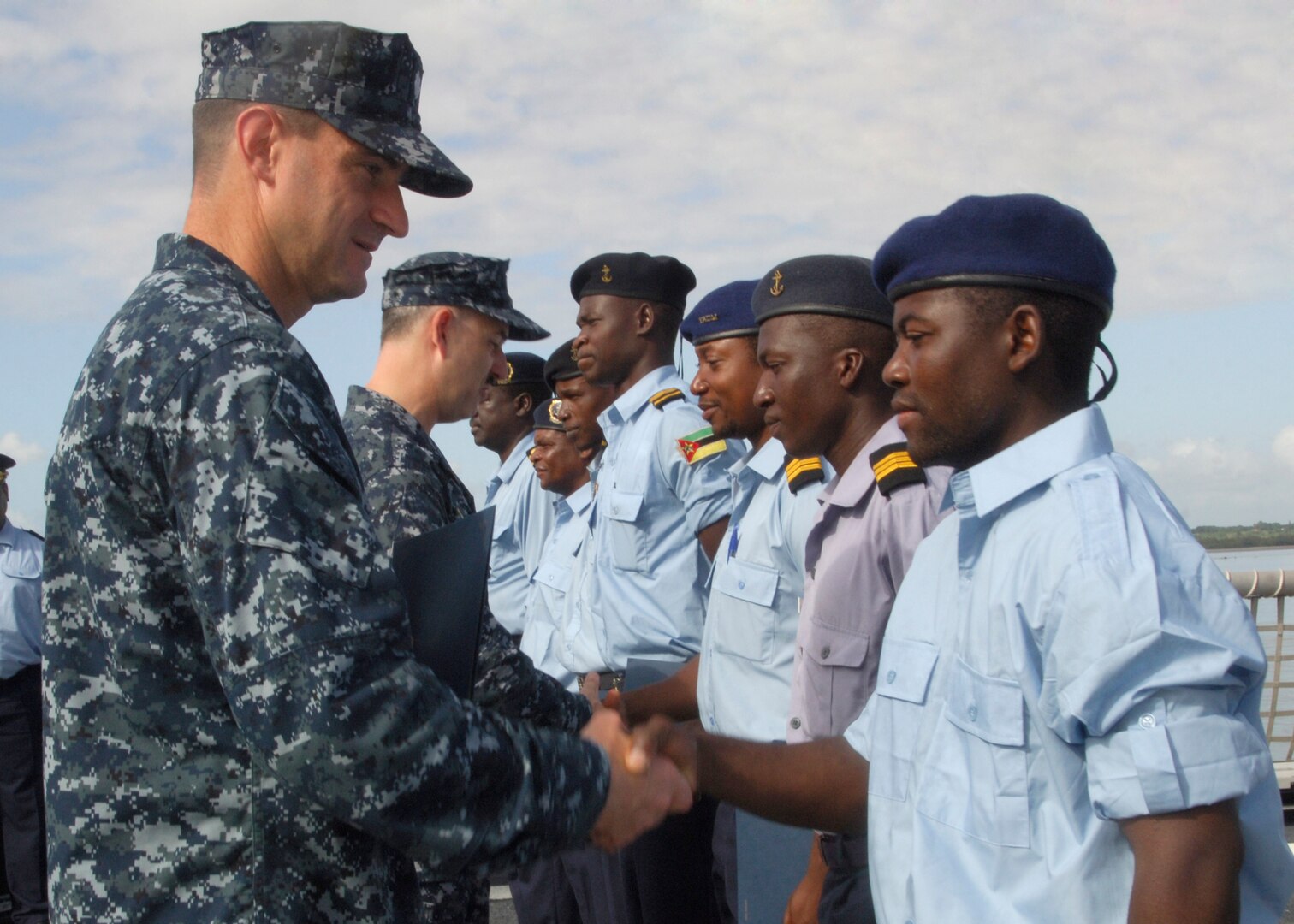 MAPUTO, Mozambique (Feb. 10, 2010)
Commander Mark Kesselring, Commanding Officer of USS Nicholas (FFG 47), congratulates a Tanzanian shiprider during a graduation ceremony aboard the flightdeck.  The event was part of Africa Partnership Station (APS) East and helped to train Tanzanian and Mozambican sailors in several areas of shipboard life.  APS East is aimed at strengthening global martime partnerships through training and other collaborative activities.  High Speed Vessel Swift (HSV 2) and USS Nicholas (FFG 47) are on a regular scheduled deployment within the U.S. 6th Fleet area of responsibility.  APS East is being conducted in cooperation with Commander, U.S. Naval Forces Africa.
U.S. Navy photo by Mass Communication Specialist 3rd Class (SW) Tracey L. Whitley.