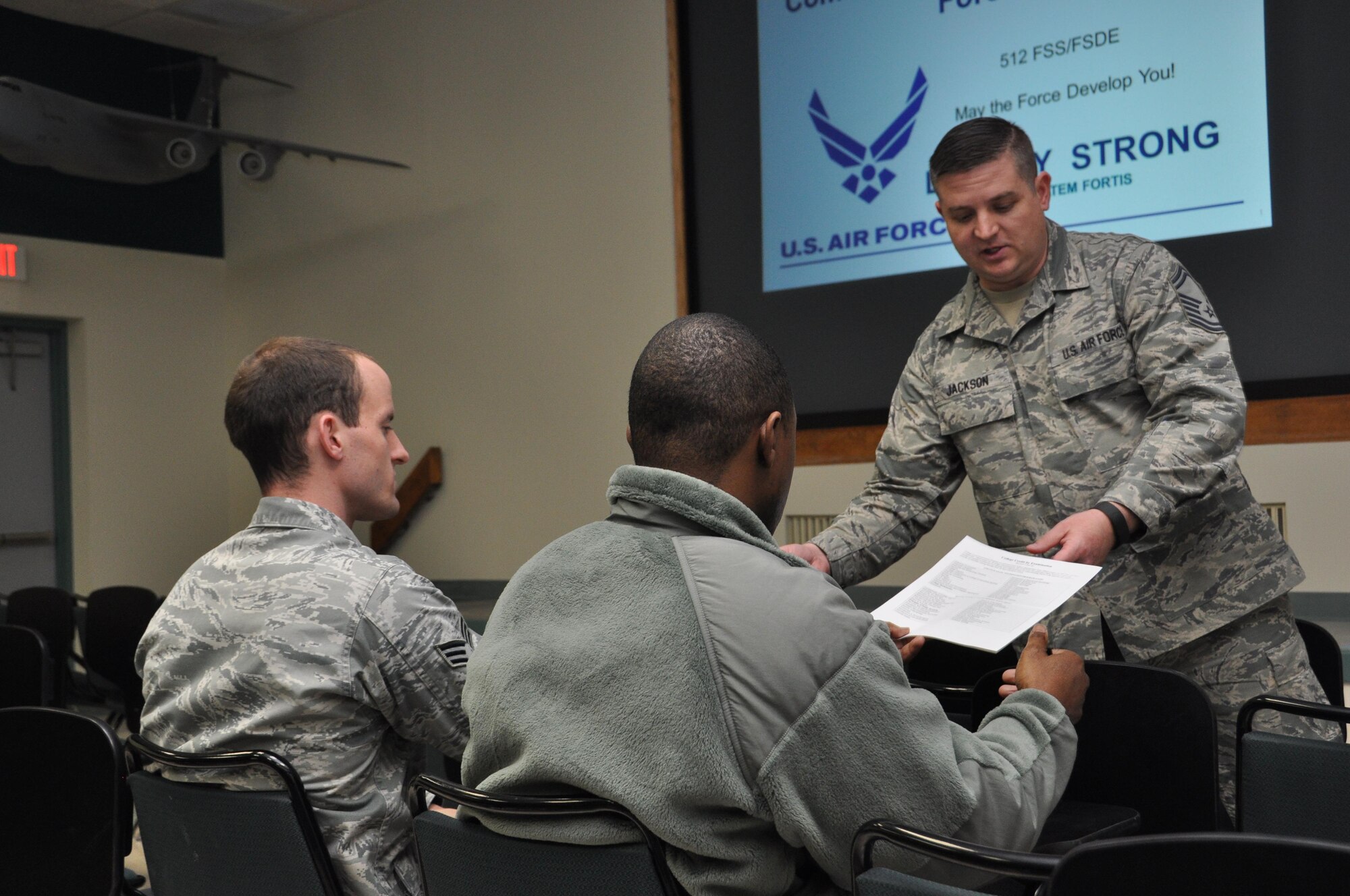 Senior Master Sgt. David Jackson (right), 512th Force Development chief, passes out informational materials about the requirements for a degree from the Community College of the Air Force to Senior Airmen Kevin Fiala (left) and Samuel Foreman, 512th Maintenance Squadron, at Dover Air Force Base, Delaware. Obtaining a CCAF degree is required for enlisted Airmen who desire promotion to senior and chief master sergeant.(U.S. Air Force photo/Staff Sgt. Joe Yanik)
