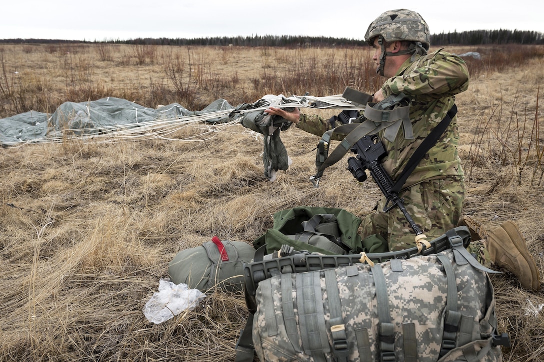 Army Staff Sgt. Jesse Lynn recovers his chute after practicing a parachute assault onto Malemute drop zone at Joint Base Elmendorf-Richardson, Alaska, April 5, 2016. Lynn is assigned to the 25th Infantry Division’s Company D, 6th Brigade Engineer Battalion, 4th Brigade Combat Team (Airborne), located in Alaska. Air Force photo by Justin Connaher
