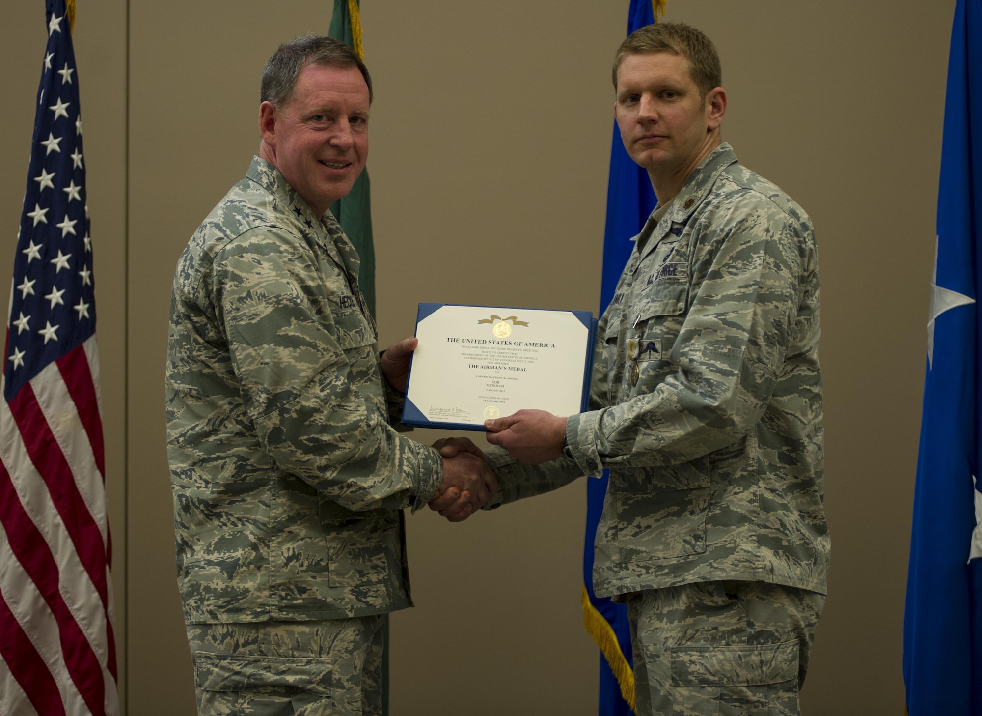 Maj. Matthew Arnold, right, the 336th Training Group chief of standards and evaluations, receives the Airman’s Medal during a ceremony April 8, 2016, at Fairchild Air Force Base, Wash. In 2013, Arnold and Tech. Sgt. Dean Criswell, the 22nd Special Tactics Squadron NCO in charge of rescue operations, were participating in a routine training exercise in Okinawa, Japan, when an HH-60G Pave Hawk went down. They helped save three of the four Airmen on the helicopter. (U.S. Air Force photo/Airman 1st Class Sean Campbell)