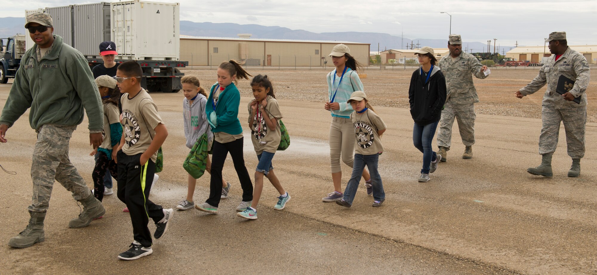 An Airman from Holloman’s Basic Expeditionary Airfield Resources (BEAR) Base leads a group of children to the next station during Operation K.I.D. (Kids Investigating Deployment), April 8 at Holloman Air Force Base, N.M. April is the Month of the Military Child. The Airmen and Family Readiness Center and Youth Center hosted Operation K.I.D. to expose military children to the different phases of deployment that their active duty family members go through.