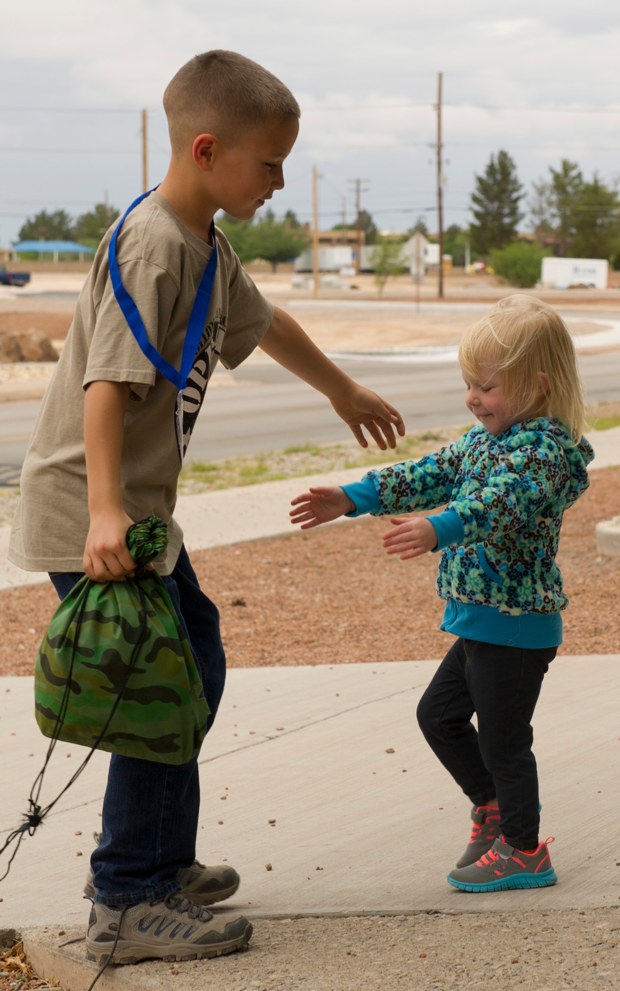 Talib Berry, 9, is greeted by his younger sister Taeryn, 2, after returning from Operation K.I.D. (Kids Investigating Deployment), April 8 at Holloman Air Force Base, N.M.  This is Talib’s second year participating in Operation K.I.D. Each year, the Airmen and Family Readiness Center and the Youth Center host Operation K.I.D. in April, the Month of the Military Child. The A&FRC believes that it is important for children to experience what their parents go through during a deployment.
