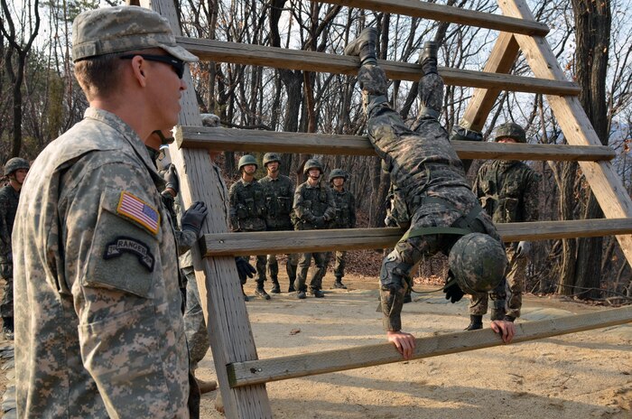 Staff Sgt. Dustin Brown (left), Headquarters and Headquarters Company, 1st Armored Brigade Combat Team “Ironhorse,” 1st Cavalry Division, leads cadets from the Korea Military Academy, Seoul, South Korea, as they move through obstacles at the Air Assault course at Camp Hovey, March 23. Ironhorse Soldiers like Brown not only worked as range safeties, but also provided tips and instructions to improve performance. (U.S. Army photo by Sgt. Fred Brown, 1st Armored Brigade Combat Team Public Affairs, 1st Cav. Div.)