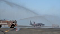 Fire engines from the 380th Expeditionary Civil Engineer Squadron render a water salute to a taxing F-15E Strike Eagle fighter aircraft at an undisclosed location in Southwest Asia, April 9, 2016. The water salute is used for to celebrate various achievements of aircrew personnel, aircraft and in this case, reaching the 1,000 combat flight hour milestone during a mission. (U.S. Air Force photo by Staff Sgt. Kentavist P. Brackin/Released)