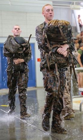 Recruits of Lima Company, 3rd Recruit Training Battalion, carry their packs after finishing the 25-meter swim during the Water Survival Basic Qualification at Marine Corps Recruit Depot San Diego, April 11. Although the majority of recruit training is focused on land-based training, combat water survival training is just as critical to learn. Annually, more than 17,000 males recruited from the Western Recruiting Region are trained at MCRD San Diego. Lima Company is scheduled to graduate June 10.