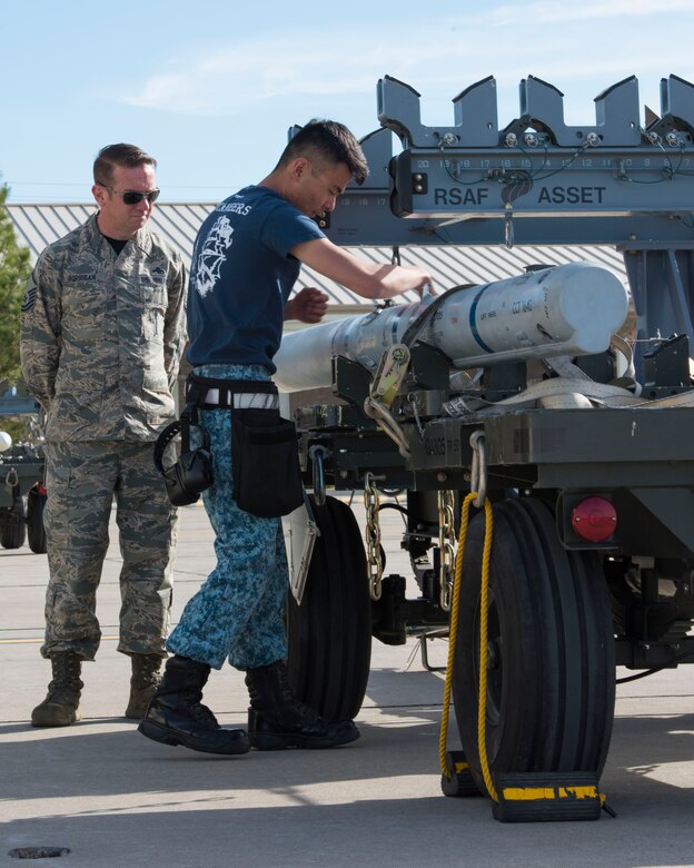 Master Sgt. Gene Horrigan, 366 Aircraft Maintenance Squadron load standardization crew chief, evaluates ME1-2 Clarence Quek, 428th Aircraft Maintenance Unit flightline crew member, as he unloads a munition, April 9, 2016, at Mountain Home Air Force Base, Idaho. Section chiefs nominated their best airmen to participate in the competition. (U.S. Air Force photo by Airman Alaysia Berry/RELEASED)