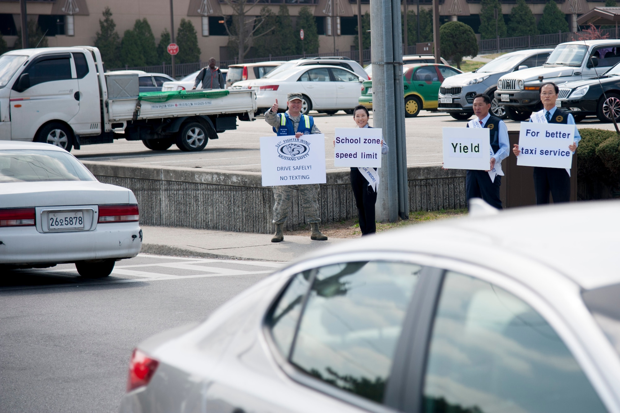 Senior Master Sgt. Sean Rouiller, 51st Fighter Wing safety superintendent, and employees from the Osan Army and Air Force Exchange Service taxi service, encourage motorists to drive safe April 11, 2016, at Osan Air Base, Republic of Korea. The safety campaign was a joint promotion with the 51st Fighter Wing safety office, AAFES taxi services and the 51st Security Forces Squadron. (U.S. Air Force photo by Staff Sgt. Jonathan Steffen/Released) 