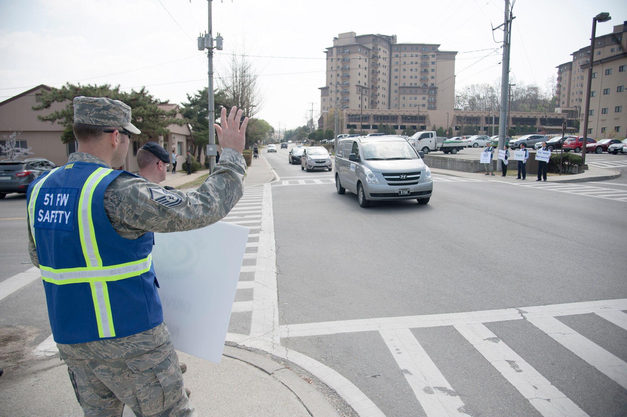 Master Sgt. Randy Christian, 51st Fighter Wing occupational safety manager, waves to drivers to encourage safe driving during a safety campaign April 11, 2016, at Osan Air Base, Republic of Korea. The safety campaign was a joint promotion with the 51st Fighter Wing safety office, AAFES taxi services and the 51st Security Forces Squadron.  (U.S. Air Force photo by Staff Sgt. Jonathan Steffen/Released)