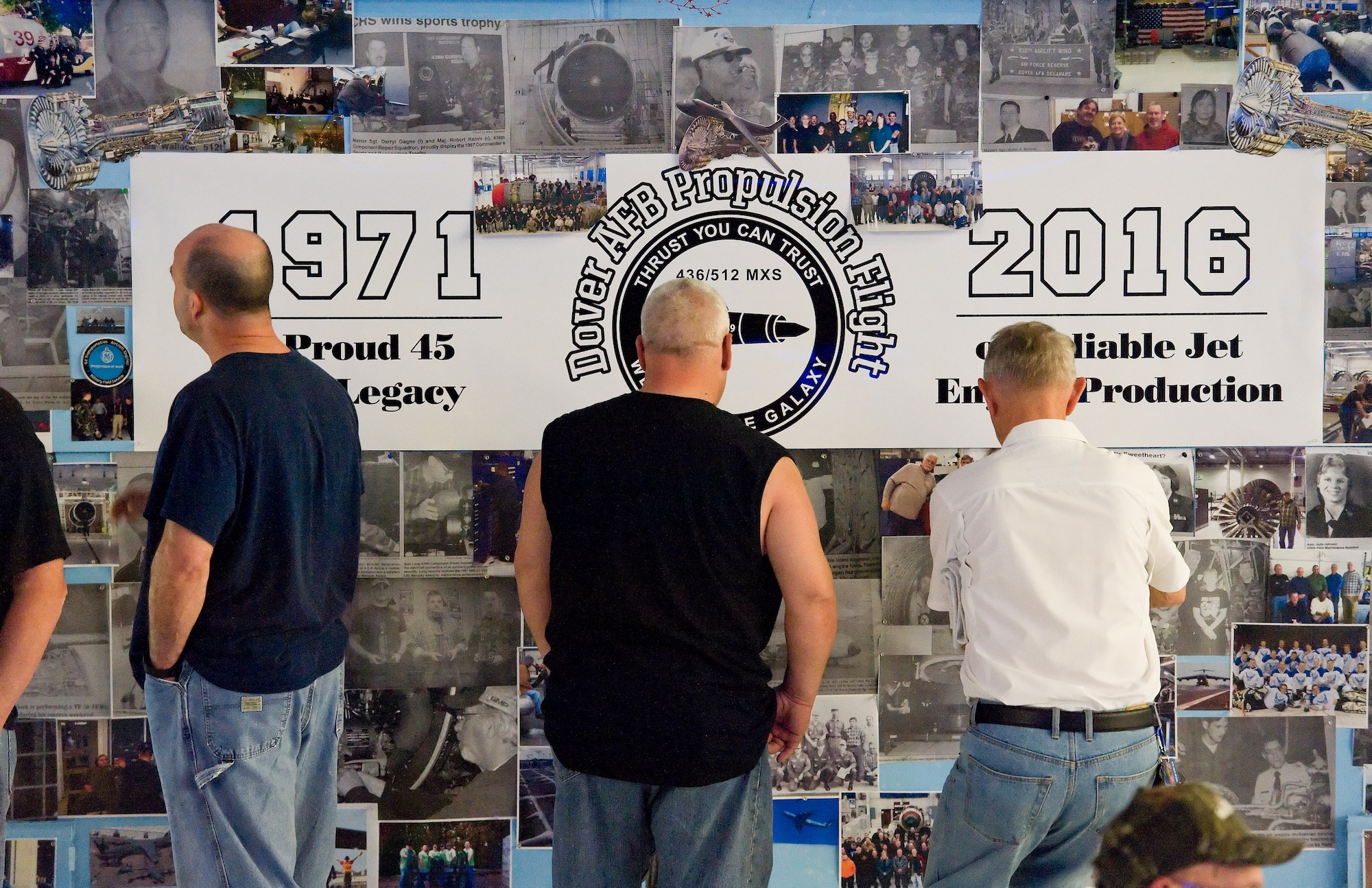 Propulsion Flight legacy celebration attendees look at one of many display boards containing photos and newspaper clippings from the past 45 years of General Electric TF39 engine production and testing for legacy C-5A/B Galaxy aircraft, March 25, 2016, on Dover Air Force Base, Del. The C-5M Super Galaxy uses GE CF6-80C2 engines and produces 50,000 pounds of thrust. (U.S. Air Force photo/Roland Balik)