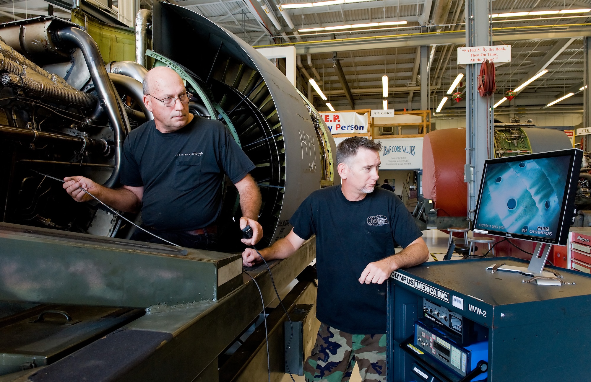 Matthew Farren, left, and Jeff Martindale, right, both 436th Maintenance Squadron jet engine technicians, borescope the combuster section of a General Electric TF39 engine July 21, 2014, on Dover Air Force Base, Del. Borescoping an engine allows technicians to inspect the engine internally for any potential problems or damage. (U.S. Air Force photo/Roland Balik)