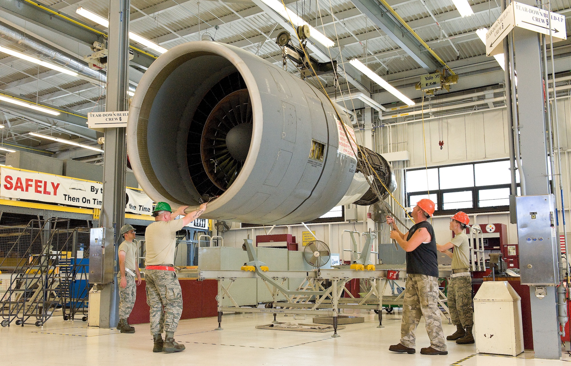 Personnel from the 436th Maintenance Squadron Jet Engine Intermediate Maintenance flight slowly hoist a General Electric TF39 engine July 21, 2014, on Dover Air Force Base, Del. The weight of an operational engine is more than 7,200 pounds. (U.S. Air Force photo/Roland Balik)