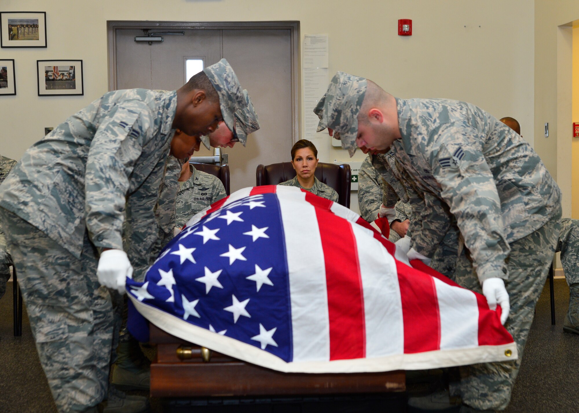 Chief Master Sgt. Sarah Sparks, 436th Airlift Wing command chief, watches the Dover Air Force Base Honor Guard drape a flag over a casket during a seven-man retiree funeral detail April 6, 2016, at Dover AFB, Del. The honor guard members showcased their mission for the new command chief as she toured their facility. (U.S. Air Force photo/Senior Airman William Johnson)