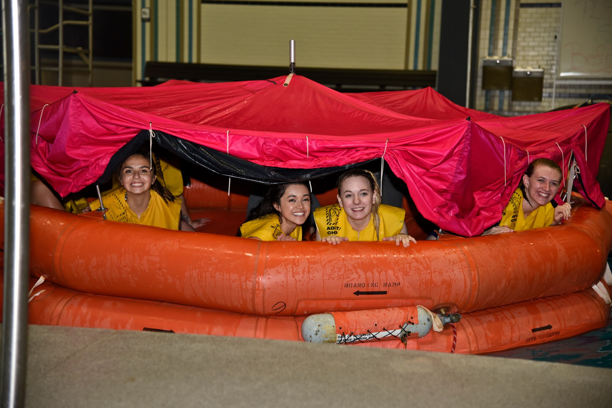 Members of the Lilac Festival Royalty Court look out of a life raft during a water survival demonstration April 11, 2016, at Fairchild Air Force Base, Wash. During the visit, the Princesses toured the 336th Training Group Survival, Evasion, Resistance and Escape school, observed a SERE water survival demonstration, learned basic water survival skills and watched a parachute jump demonstration. (U.S. Air Force Photo/Airman 1st Class Taylor Bourgeous)
