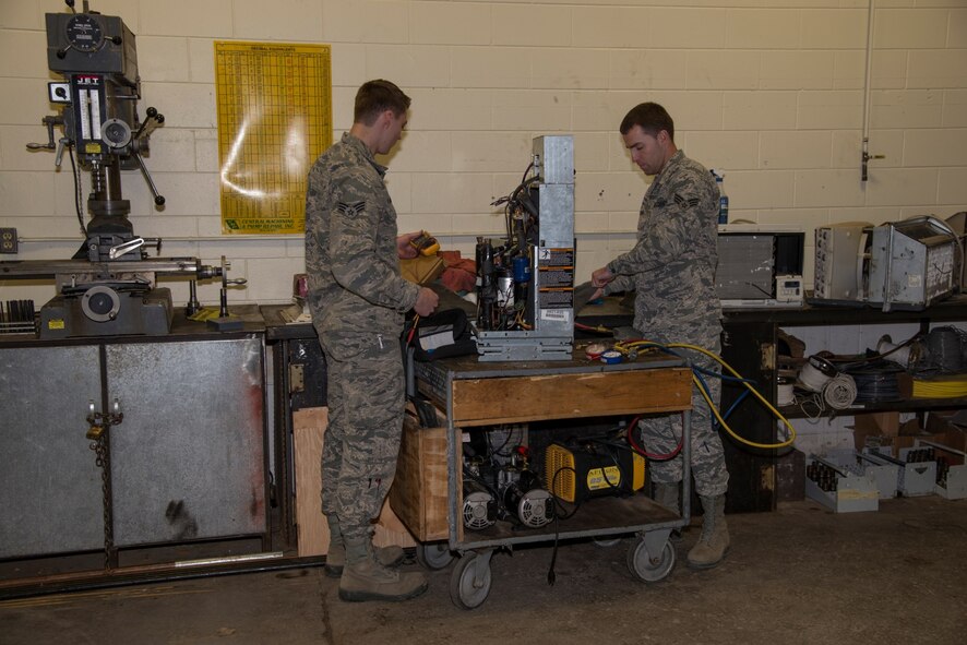 Senior Airman Mark Brisbois and Senior Airman Michael Robinson, 5th Civil Engineer Squadron heating, ventilation and air conditioning journeymen, work on a geothermal heat pump at Minot Air Force Base, N.D., April 5, 2016. HVAC repairs and replaces the heating and cooling units, among other things, for the squadrons on base. (U.S. Air Force photo/Airman 1st Class Christian Sullivan)