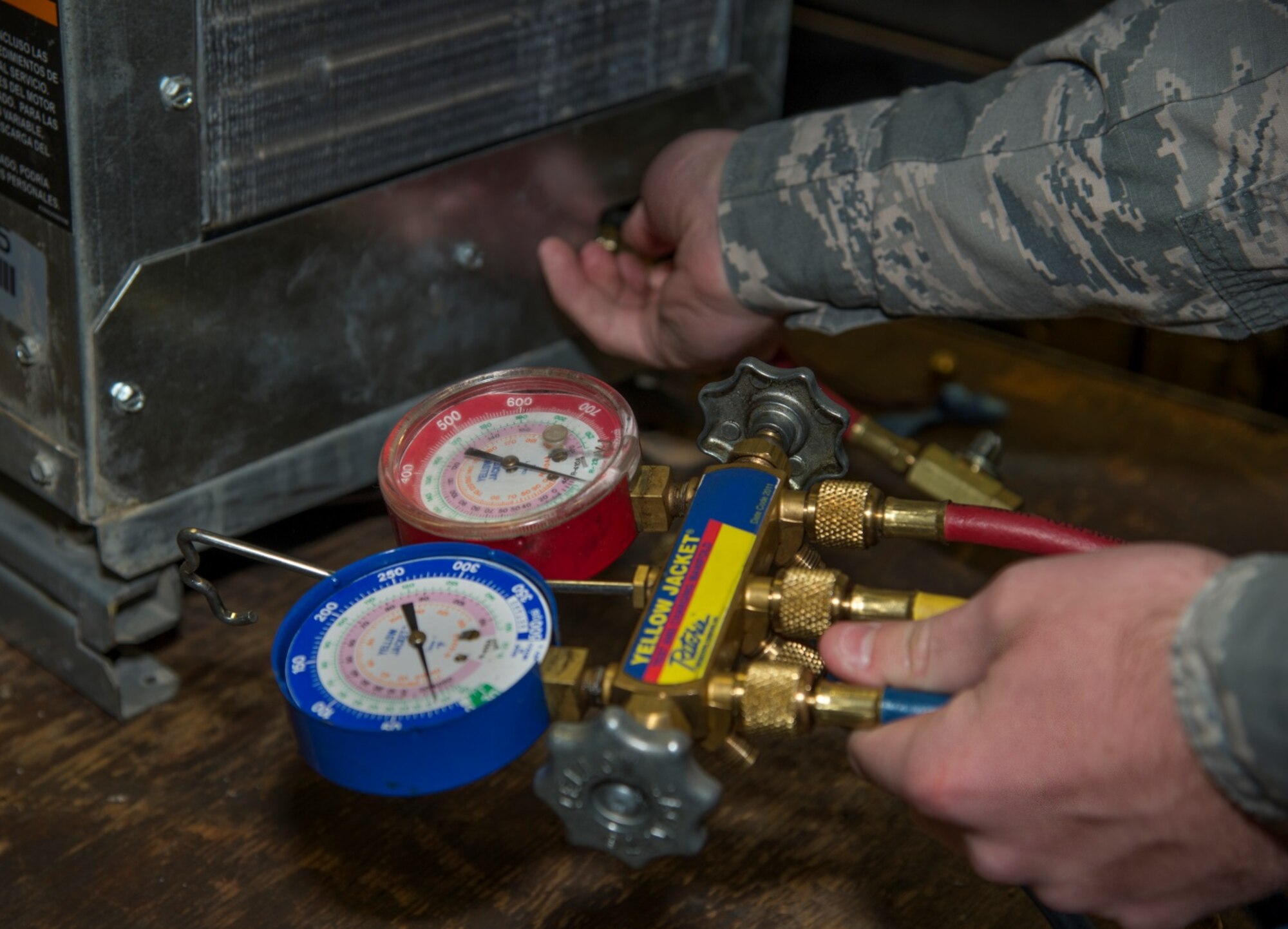 Senior Airman Michael Robinson, 5th Civil Engineer Squadron heating, ventilation and air conditioning journeyman, uses a gauge to test a geothermal heat pump at Minot Air Force Base, N.D., April 5, 2016. Geothermal heat pumps are high efficiency pumps that help heat just about every building on base. (U.S. Air Force photo/Airman 1st Class Christian Sullivan)