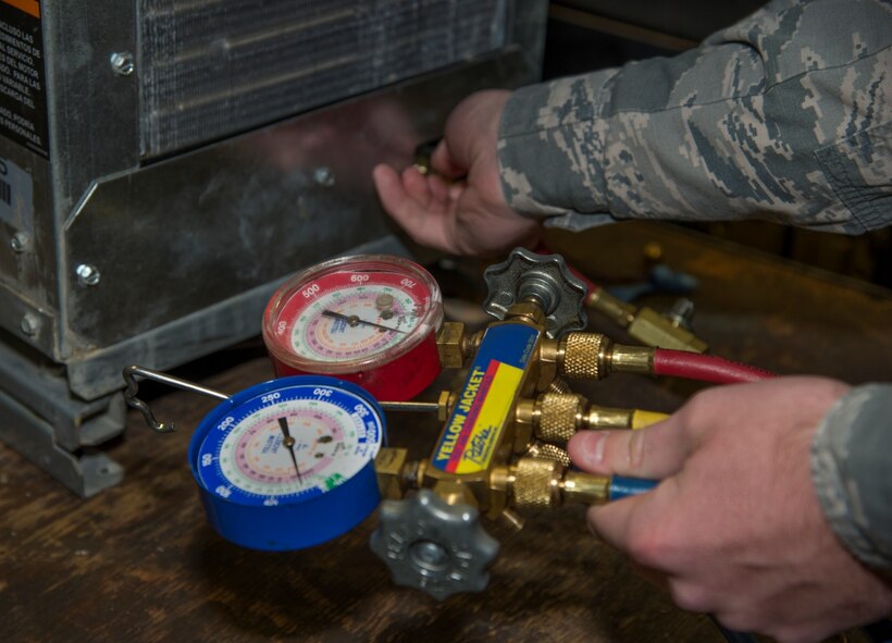 Senior Airman Michael Robinson, 5th Civil Engineer Squadron heating, ventilation and air conditioning journeyman, uses a gauge to test a geothermal heat pump at Minot Air Force Base, N.D., April 5, 2016. Geothermal heat pumps are high efficiency pumps that help heat just about every building on base. (U.S. Air Force photo/Airman 1st Class Christian Sullivan)