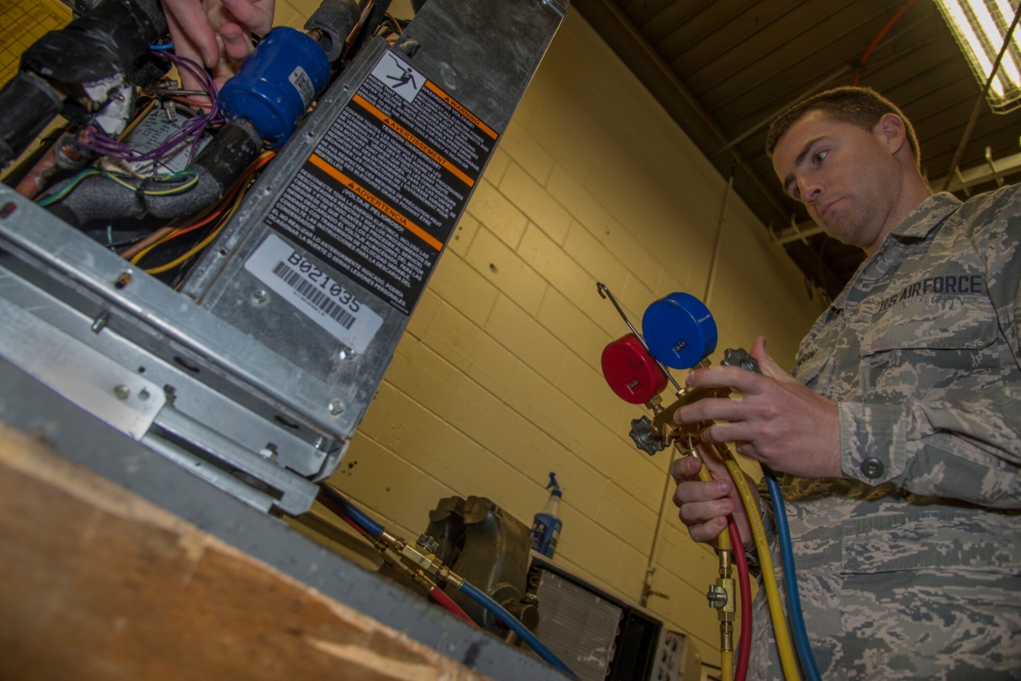 Senior Airman Michael Robinson, 5th Civil Engineer Squadron heating, ventilation and air conditioning journeyman, works on a geothermal heat pump at Minot Air Force Base, N.D., April 5, 2016. HVAC repairs and replaces the heating and cooling units, among other things, for the squadrons on base. (U.S. Air Force photo/Airman 1st Class Christian Sullivan)