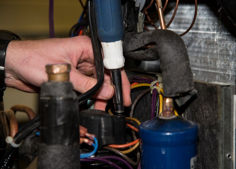 Senior Airman Mark Brisbois, 5th Civil Engineer Squadron heating, ventilation and air conditioning journeyman, works on a geothermal heat pump at Minot Air Force Base, N.D., April 5, 2016. Geothermal heat pumps are high efficiency pumps that help heat just about every building on base. (U.S. Air Force photo/Airman 1st Class Christian Sullivan)