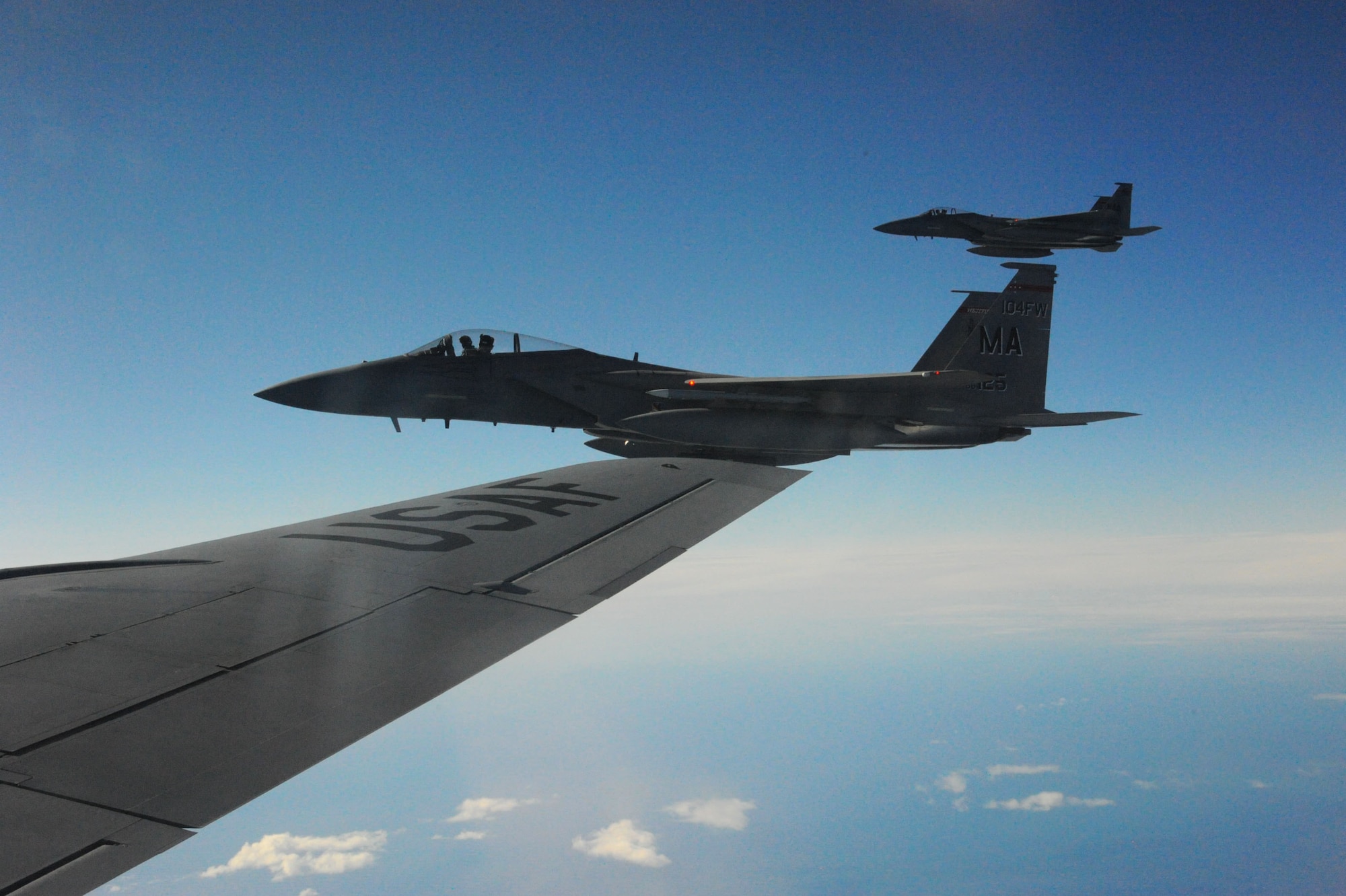 Two U.S. Air Force F-15C Eagle fighter aircraft assigned to the 104th Fighter Wing, Barnes Air National Guard Base, Mass., fly alongside a U.S. Air Force KC-135 Stratotanker from the 916th Air Refueling Wing, Air Force Reserve Command, Seymour Johnson, N.C. after taking fuel in the skies over Iceland while conducting Air Surveillance operations. Deterrence missions such as this communicates that the U.S. is serious about security and stability in the region. (U.S. Air Force photo by Master Sgt. Kevin Nichols/Released)