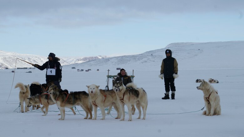 THULE AIR BASE, Greenland – Tech. Sgt. Jeremy Sheehan hunkers down in preparation the Armed Forces Day 10 km dog sledge race.  Sheehan was one of only 12 people selected to accompany a hunter on the trip. (U.S. Air Force Photo by Master Sgt. Stoney Bair)